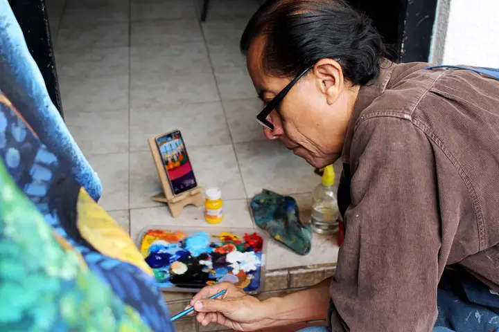 Artista trabaja a ras de piso sobre un cráneo de gran formato.