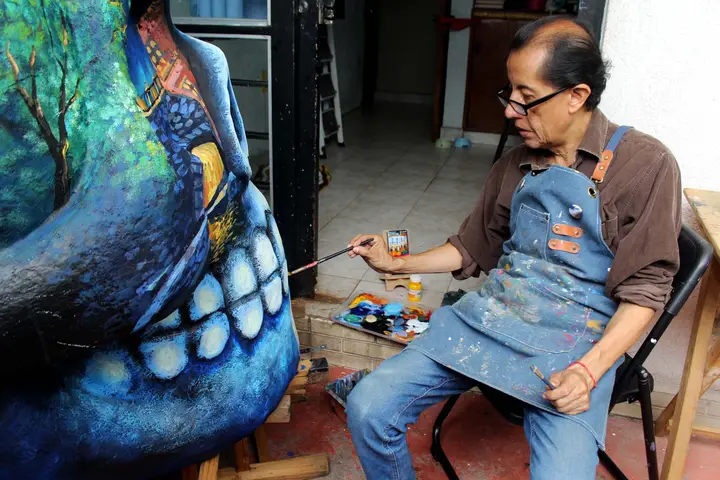 El artista da los últimos toques al cráneo azul.