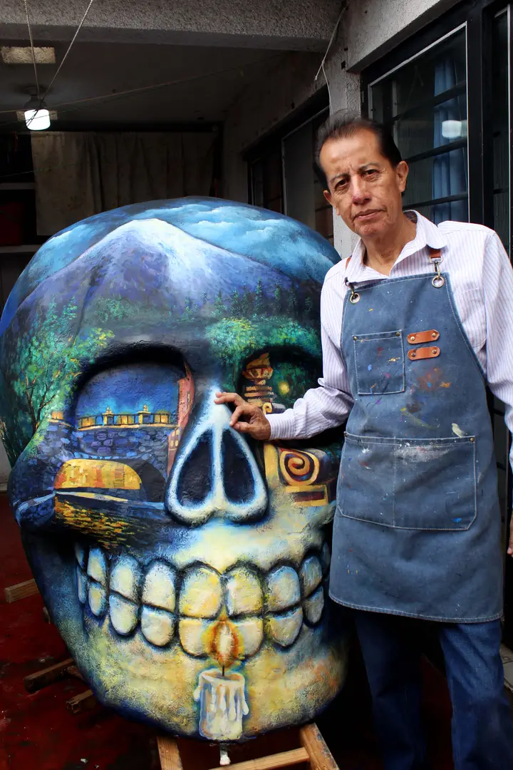 El artista posa con la calavera que retrata la noche de los fieles difuntos.