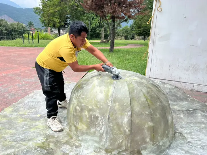 Pulido de una esfera de fibra de vidrio en la explanada.