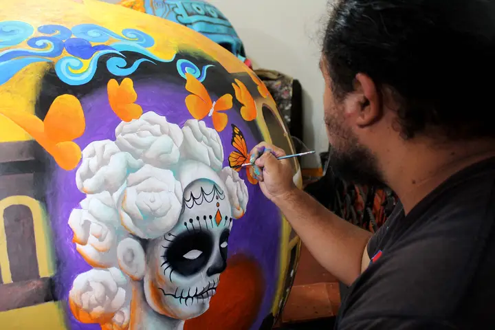 Pinceladas finales sobre una calavera con un personaje de cabello blanco.